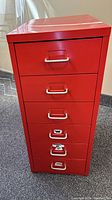Red metal drawer unit showing all six drawers with silver handles.