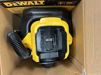 Top view of the untested DeWalt vacuum showing the filter compartment and attached flexible hose in original box.