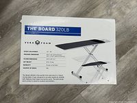 Product box for THE BOARD 320LB ironing table by Vera Foam showing the features, measurements, and image of the ironing table.