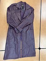 Full view of the long purple faux leather Joker jacket laid out flat showing front buttons, collar, and cuff details.