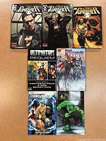 Seven Marvel Comics books arranged on a table showing front covers of The Punisher (3 editions), Ultimatum Requiem, Thor, Fantastic Four Inhumans, and Hulk comics.