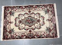 Full view of the rectangular wool carpet showing entire design with central floral medallion and border.