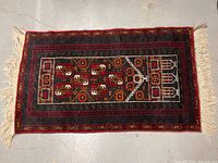 Full view of the 100% handmade wool carpet laid flat showing geometric design and fringed edges.