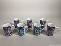 Set of seven vintage Dunoon stoneware mugs arranged in two rows, showing colorful Charles Rennie Mackintosh inspired designs.