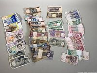 Overview of assorted international banknotes laid out on tabletop
