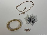 Overview of the jewelry set showing the necklace with pendant, hinged bangle bracelet, large crystal brooch, and stud earrings