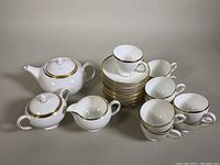 Full set of vintage Wedgwood 'California' bone china tea set including teapot, creamer, sugar bowl, 9 teacups and 16 saucers all white with gold trim.