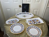 Five-piece set displayed on table showing detailed ornamental pattern and gold trim on trays and plates