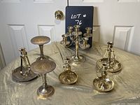 Full set of 6 brass candle holders including a 5-arm candelabra and 5 individual holders of various styles and sizes.