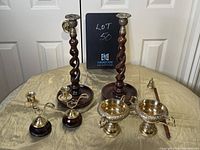 Full set of large and small candle holders, stemmed bowls, and candle snuffer arranged on table