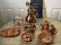Full view of all copper items in the lot including samovar, cream and sugar set, butter dish, pickle dish, salt and pepper shakers.