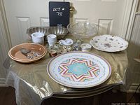 Photo of assorted serving, baking, and entertaining items including platters, bowls, cups, and utensils arranged on table