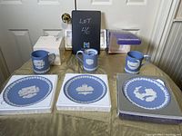 Lot of four Wedgewood Jasperware items shown on table including two Christmas plates, one round plate, and one mug.