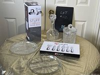 Full lot view showing wine box, decanter, ice bucket, cheese utensils box, and glass relish dishes on gold cloth