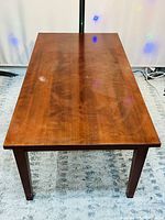 Top view of polished wooden rectangular table showing natural wood grain surface.