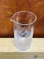 Front and side views of the clear glass juice jar with etched decorative pattern and bird motif.