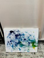 Front view of abstract painting on canvas with blue, green, and yellow brushstrokes.