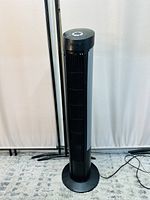 Front view of the Seville Classics tower fan showing the tall black grille and circular control panel on top.