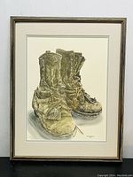 Front view of the watercolor painting depicting worn work boots, signed Brown Heather 1984 in bottom right corner, mounted in a wooden frame without glass.