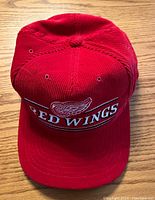 Front view of red corduroy Detroit Red Wings NHL hockey hat showing embroidered team logo on front.
