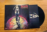 Front of the record cover showing the album artwork depicting a muscular figure with swords and a colorful background.