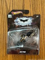 Front view of sealed Hot Wheels Bat-pod toy in original packaging showing branding and Bat-pod vehicle.