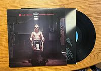 Front cover of The Michael Schenker Group vinyl album showing man strapped to chair under light.