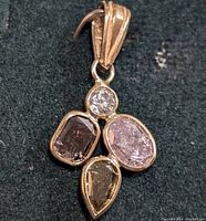 Front view of pendant showing four bezel-set diamonds and bail