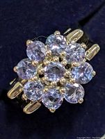 Close-up front view of the amethyst and blue topaz cluster ring showing multiple stones in a floral pattern.