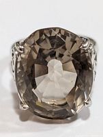 Close-up image of the front of the silver ring with the large faceted smoke quartz stone showing its oval shape and color.