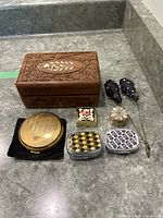 Overview photo of all items in the lot: wood carved jewelry box, four small pill or compact boxes, two black beaded hat pins.