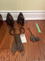 Photo showing all items including two cast iron irons, large shears, and the bell cluster on floor.