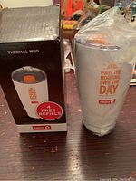 Photo of the Circle K thermal mug wrapped in plastic next to its original black box showing product image and brand details.