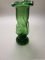 Front view of green glass hand-shaped vase with fluted top edge and solid base.