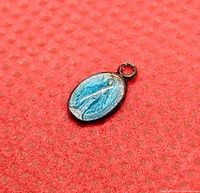 Close-up of the front side showing the raised Virgin Mary figure and blue patina beneath