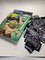 Photo showing Star Wars birthday party favor pack with characters Obi-Wan Kenobi, Anakin Skywalker, and Qui-Gon Jinn on the package. Green background with Star Wars logo.