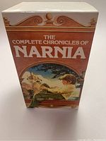 Front view of the decorated slipcase for The Chronicles of Narnia 7-book set featuring illustration of a boy reading and castle.