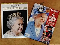 Two Maclean's magazines side by side on a wooden surface, showing cover images of Queen Elizabeth II and title text related to the Diamond Jubilee celebration.