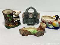 Full view of all four animal planters: panda on tree stump, elephant pair, mossy log, and mallard duck.