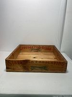 Front view of wooden crate showing 'Crossed Fish Brand' text inside and fish graphic on the wood.