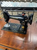 Side view of the Singer sewing machine showing the full machine body with decorative gold decals.