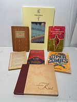 Photo showing seven assorted books including a Japanese art book 'Hiroshige' in its slipcase, 'The Harmless People', 'Unser Kind' notebook, 'The Super Lemnis', and smaller books.