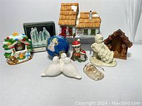 Overview of all Christmas decor items arranged including nativity scenes, figurines, ornaments, and a candle holder.