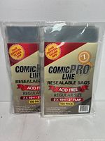Two packs of Comic Pro Line resealable comic sleeves, each pack labeled as 100 count, acid free, 7" x 10.5" with 2" flap, packaged in clear plastic