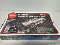 Top view of the Hubble Space Telescope model box showing branding, image of the telescope, and details about the model.