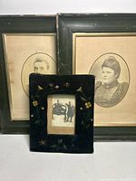 Pair of Victorian framed photographs with green wooden frames, one man one woman, 17 wide by 22 high, showing wear and age.