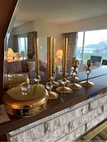 Full view of three tall brass and crystal candle sticks, four shorter brass and crystal candle sticks, and round brass covered dish with crystal knob on top.