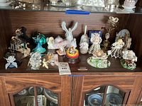 Wide view of shelf with musical swan, animal and angel figurines arranged across a wooden surface
