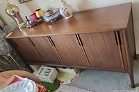 Front view of sideboard with closed sliding doors and decorative objects on top.