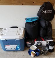 Full assembly of cooler, tent bag, sleeping bags, pad, pillow, lantern, dishes, and bags